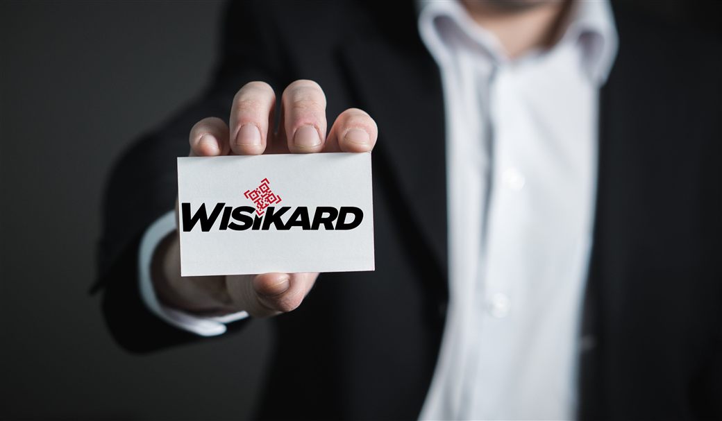 Professionnel présentant sa carte de visite numérique Wisikard avec QR Code